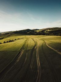 Scenic view of road amidst field against sky