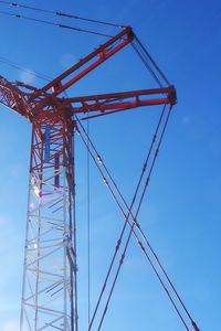 Low angle view of crane against blue sky