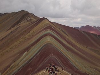 Scenic view of mountain range against cloudy sky