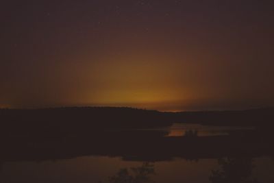 Scenic view of lake against sky at sunset