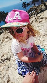Portrait of girl wearing sunglasses sitting on beach