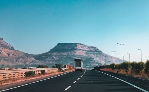 Road by mountain against clear sky