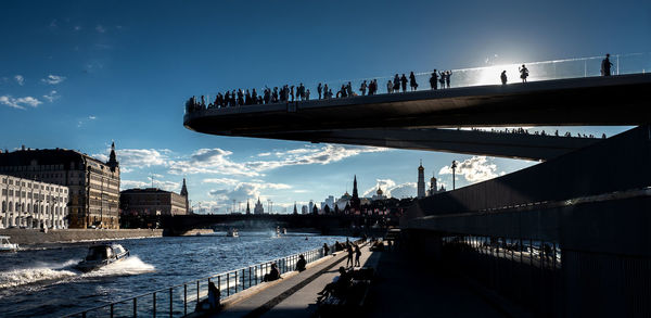 Bridge over river in city against sky