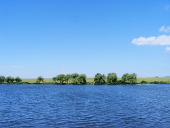 Scenic view of lake against blue sky