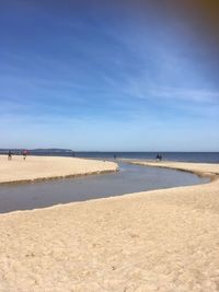 Scenic view of beach against blue sky