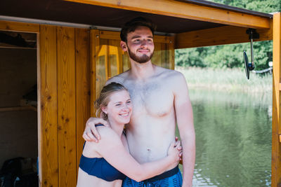 Smiling couple embracing by lake