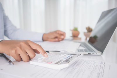 Midsection of man using laptop on table