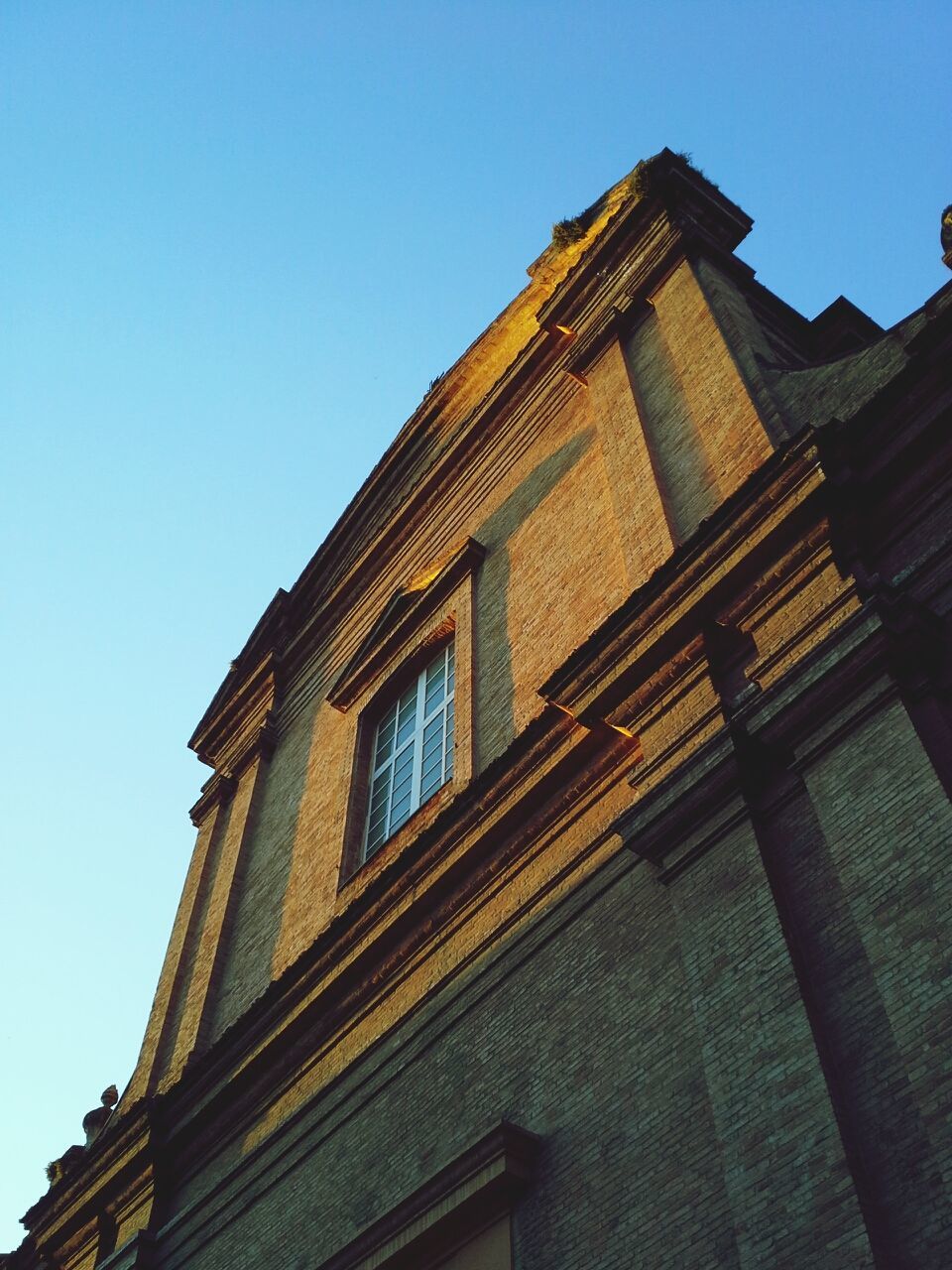 architecture, building exterior, built structure, low angle view, clear sky, window, blue, building, history, sunlight, day, outdoors, no people, copy space, old, facade, sky, exterior, city, residential building