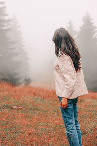 Rear view of woman standing on field 