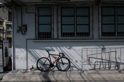 Bicycle parked on footpath by building