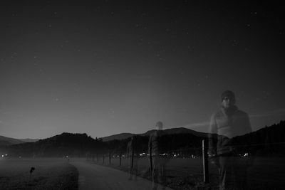 Young woman on road against sky at night