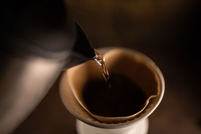 Close-up of hot water pouring in coffee cup