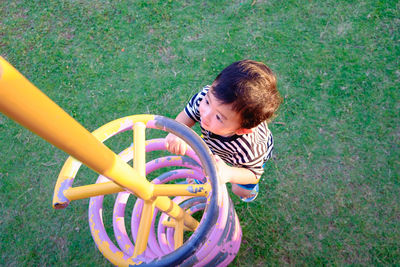 Cute boy playing on play equipment at park