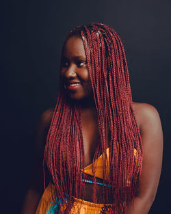 Portrait of a smiling young woman over black background