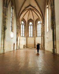 Rear view of young woman standing in empty church
