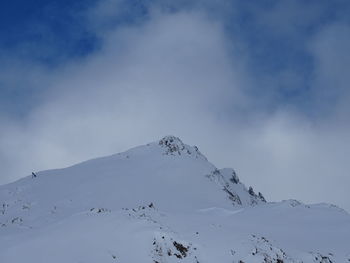 Low angle view of snow covered mountain against sky