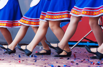 Low section of young women wearing uniform dancing on stage