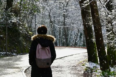 Rear view of woman standing in forest