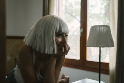 Young woman with head in hands sitting at home