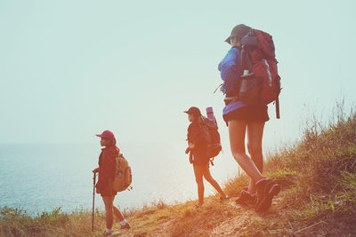 People walking on land against clear sky