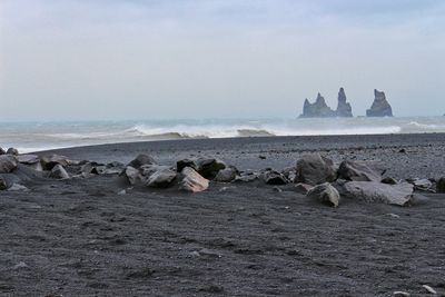 Rocks on beach against sky