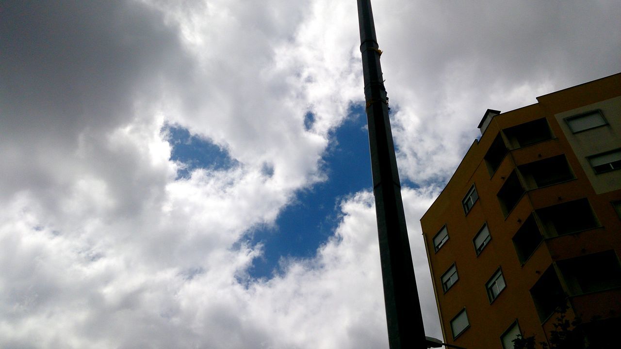 architecture, building exterior, low angle view, built structure, sky, cloud - sky, cloudy, cloud, building, city, day, outdoors, residential building, tall - high, no people, tower, residential structure, window, weather, high section