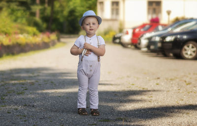 Boy in casual clothing on a car parking behind hotel.