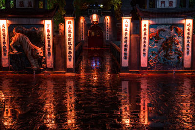 Illuminated wet glass building at night