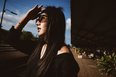 Woman shielding eyes in city