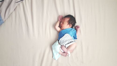 High angle view of baby girl lying on bed at home
