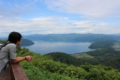 Woman looking at mountains against sky