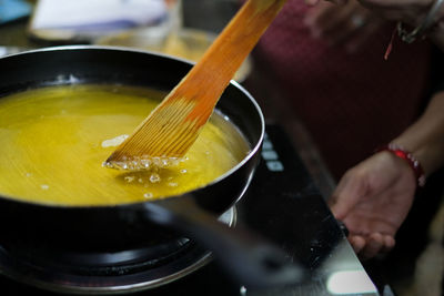 Close-up of frying pan with wooden spoon in kitchen