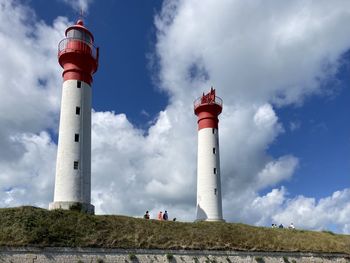 Lighthouse by sea against sky