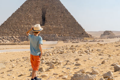 Boy walking in front of the pyramid of mikerin on the giza plateau