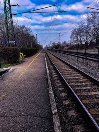 View of railway tracks along bare trees