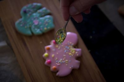 High angle view of hand preparing cookies on table