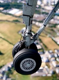 Close-up of aircraft landing gear while flying over city