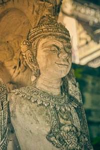 Close-up of buddha statue against historic building