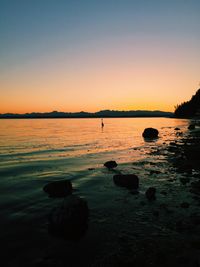 Scenic view of river against clear sky at dusk