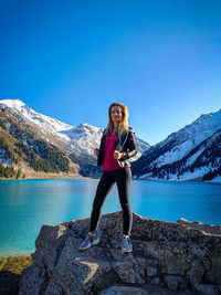 Full length of young woman against blue sky