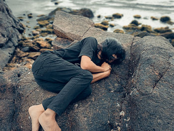 High angle view of woman sitting on rock