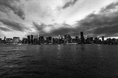 Cityscape by sea against sky in city