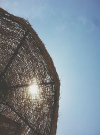 Low angle view of sunlight against clear blue sky