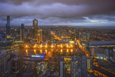 Illuminated cityscape against sky at night