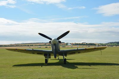 Airplane on airport runway against sky