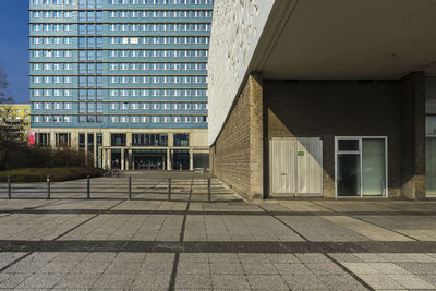 Empty footpath by building in city