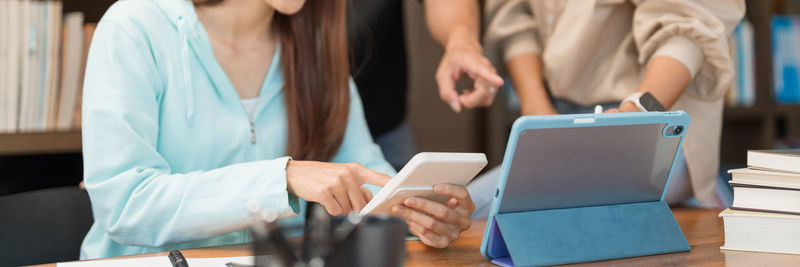 Education concept, students pointing quiz on tablet and use calculator to doing math quiz of tutor.