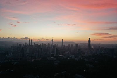 Aerial view of buildings in city during sunset