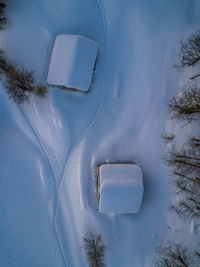 Snow covered land by trees against sky