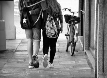 Low section of people walking on bicycle